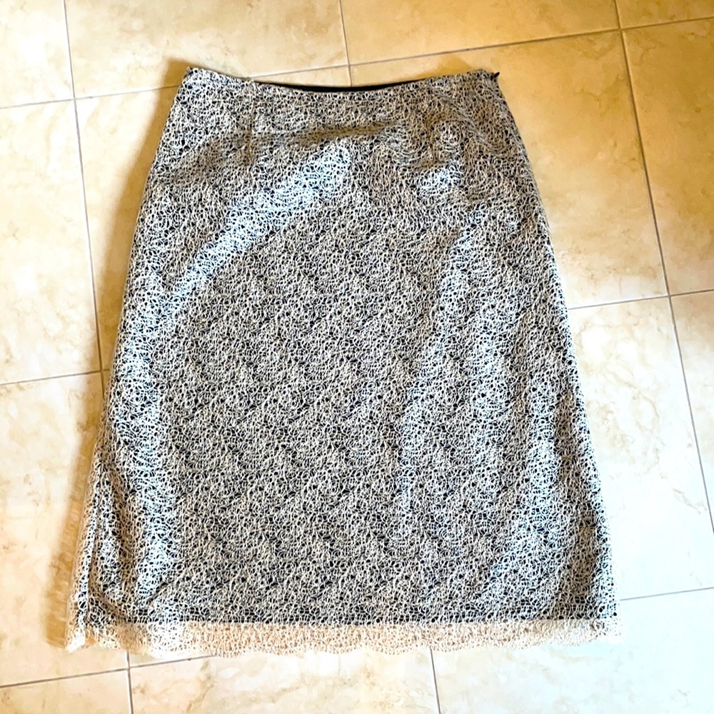 Very cool soft lace like material lays beautifully over black skirt